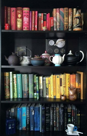Bookshelf containing books grouped by colour.